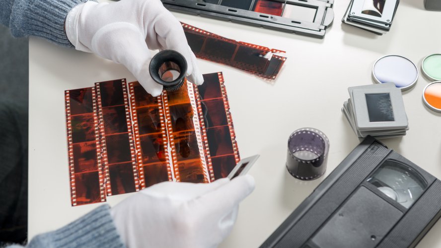 Photo scanning technician handling slides with care